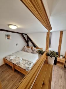 Penzion V Suchu في تشيسكي كروملوف: غرفة نوم بسرير في غرفة ذات أرضيات خشبية