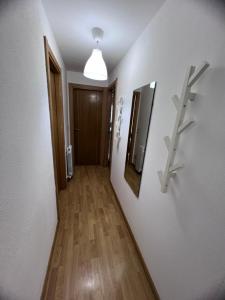 un pasillo con paredes blancas y suelo de madera en Apartamento en Sabiñánigo con amplia y soleada terraza en Sabiñánigo