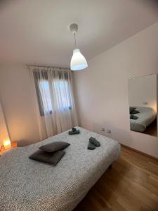 1 dormitorio con cama y espejo grande en Apartamento en Sabiñánigo con amplia y soleada terraza, en Sabiñánigo