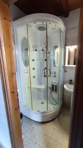 uma cabina de duche em vidro na casa de banho com um lavatório em ΞΕΝΩΝΑΣ ΘΕΑ em Palaios Agios Athanasios