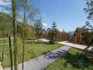 a backyard with a wooden fence and a house at RoomQuest Kid Tung Khao in Ban Huai Sok Noi