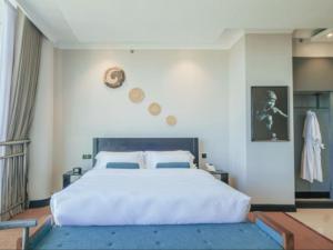 una camera da letto con un grande letto bianco con monete sul muro di Sanna Boutique Hotel ad Arusha