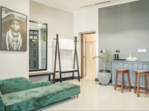ein Wohnzimmer mit einem grünen Sofa und einem Spiegel in der Unterkunft Sanna Boutique Hotel in Arusha