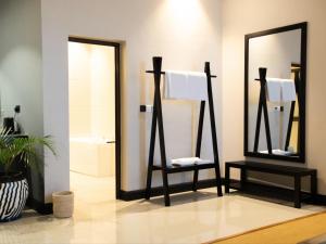 a bathroom with a towel rack and a mirror at Sanna Boutique Hotel in Arusha