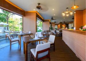 a restaurant with tables and chairs and a bar at HA Hotel Apartments Ocean Front in Hoi An