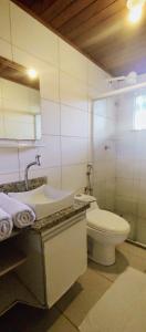 y baño con lavabo, aseo y espejo. en Espaçoso apartamento a 50mt do mar en Morro de São Paulo