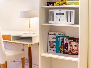 a book shelf with a microwave and books at Pass the Keys Family Friendly 3 Bed Home In Pinner Pets Welcome in Pinner