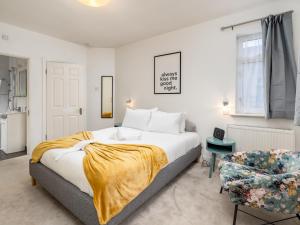 1 dormitorio con 1 cama grande y 1 silla en Family Friendly 3 Bed Home In Pinner Pets Welcome - Pass the Keys, en Pinner