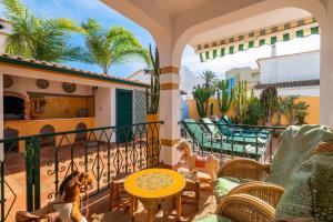 eine Terrasse mit einem Tisch und Stühlen auf dem Balkon in der Unterkunft Riad Serpa Galé - Luxury, private pool, AC, wifi, 5 min from the beach in Guia