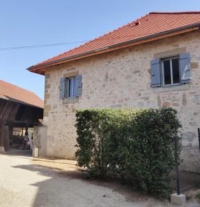 Un bâtiment avec deux fenêtres et un bush devant lui dans l'établissement Au Coin Du Chemin, à Chambéry