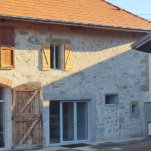 Casa de piedra con puertas y ventanas de madera en Au Coin Du Chemin en Chambéry