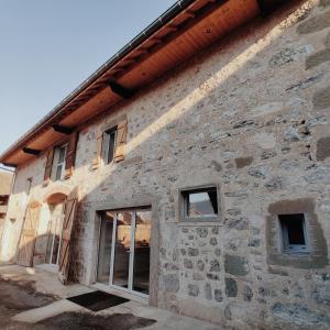 ein Steingebäude mit seitlichen Fenstern in der Unterkunft Au Coin Du Chemin in Chambéry