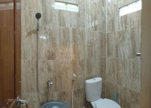 uma casa de banho com um chuveiro e um WC. em Kampung house Godean Sleman Yogyakarta em Godean