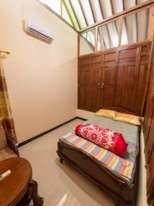 uma pequena cama num quarto com uma janela em Kampung house Godean Sleman Yogyakarta em Godean