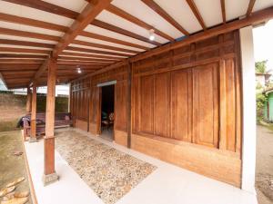 an open garage with wooden doors on a house at Kampung house Godean Sleman Yogyakarta in Godean
