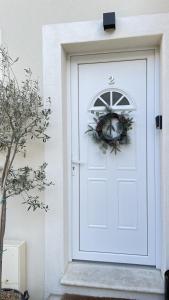 a white door with a wreath on it at Le Clos Du Moulin 2 - Maison et jardin, proche Avignon, en Provence in Entraigues-sur-la-Sorgue