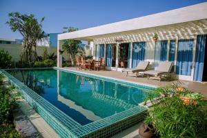 a swimming pool in front of a house at 4br Villa River Deck, Pool, Bbq & Garden in Thuan An