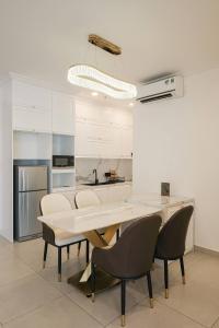 a white kitchen with a table and chairs in it at Compassone - 2bd Luxury Apartment Free Gym & Pool in Ấp Phú Thọ