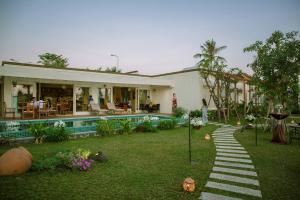 een huis met een tuin en een zwembad bij 4br Villa River Deck, Pool, Bbq & Garden in Thuan An