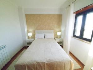a bedroom with a large bed with two windows at Caldas da Rainha's Green & Brown in Caldas da Rainha