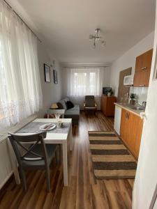 een woonkamer met een tafel en een keuken bij Pokoje Pod Kasztanami Jantar in Jantar