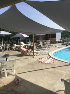 Tienda grande sobre una piscina con sillas y sombrillas en La Varenne, en Changy