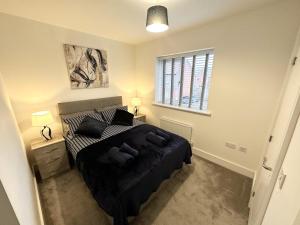 a bedroom with a black bed and a window at Fairway Villa in Stafford