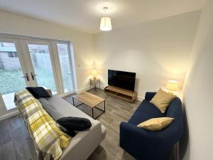 ein Wohnzimmer mit einem Sofa und einem TV in der Unterkunft Fairway Villa in Stafford