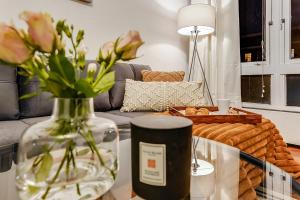 a vase with flowers on a table in a living room at Spacious 1 Bed next to Baker St in London