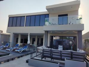 Casa con sillas azules y balcón en Al Qand Chalet For Families Only en Half Moon Bay