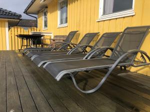 una fila de sillas sentadas en una terraza con un piano en Villa with pool and sauna, en Porsgrunn