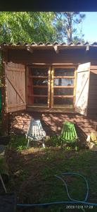 un cobertizo con dos puertas y una manguera en el patio en Magavilla en Barra de Valizas