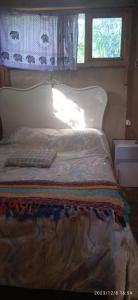 1 cama con cabecero blanco y ventana en Magavilla en Barra de Valizas