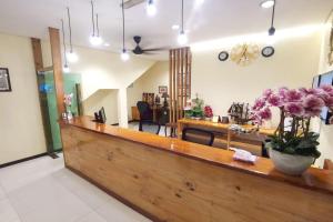 a lobby with a counter with flowers on it at OYO 90883 Pavilion Inn Hotel in Lumut