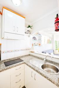eine Küche mit weißen Schränken und einem Waschbecken in der Unterkunft Holidays Beach Torrox - 16 in Málaga
