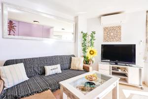 ein Wohnzimmer mit einem Sofa und einem TV in der Unterkunft Holidays Beach Torrox - 16 in Málaga