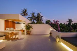 an outdoor kitchen and dining area of a house at Las Hermanas Villa by MAR Bali in Dalung