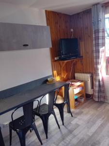 a living room with a table with chairs and a television at chamois tétras marmotte in Allos