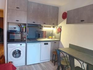 a small kitchen with a washing machine and a table at chamois tétras marmotte in Allos