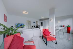 sala de estar con sillas rojas y mesa en Wonderful Blick Apartment Orselina - Happy Rentals, en Orselina