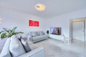 a white living room with a couch and a table at Wonderful Blick Apartment Orselina - Happy Rentals in Orselina