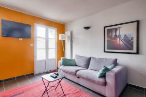 een woonkamer met een bank en een tv bij Jolie maison en residence - paradis des familles - Re Liberte in La Flotte