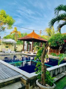 einen Resortpool mit einem Pavillon und einer Palme in der Unterkunft Pondok Baruna Garden in Nusa Lembongan