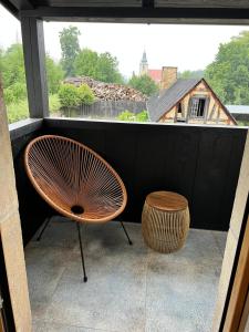 une chaise et un tabouret devant une fenêtre dans l'établissement Zajazd Hubert, à Walim