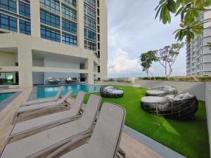 a patio with chairs and a swimming pool in a building at Paradigm Residence in Johor Bahru