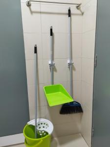 a bathroom with a broom and a green bucket at Paradigm Residence in Johor Bahru