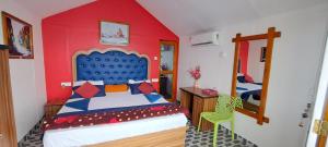 a bedroom with a bed with a blue head board at Pacific Sunset View Palolem in Palolem