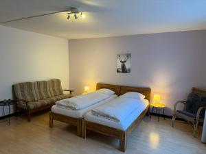 a bedroom with two beds and a couch at Downtown Apartments in Interlaken