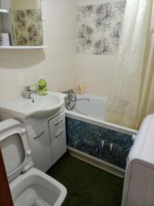 y baño con lavabo, aseo y bañera. en Уютная квартира в центре города en Karagandá
