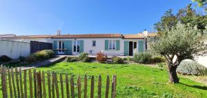 une maison blanche avec une clôture dans une cour dans l'établissement Proche plage de la Cible, villa familiale avec annexe, jardin et parking, à Saint-Martin-de-Ré